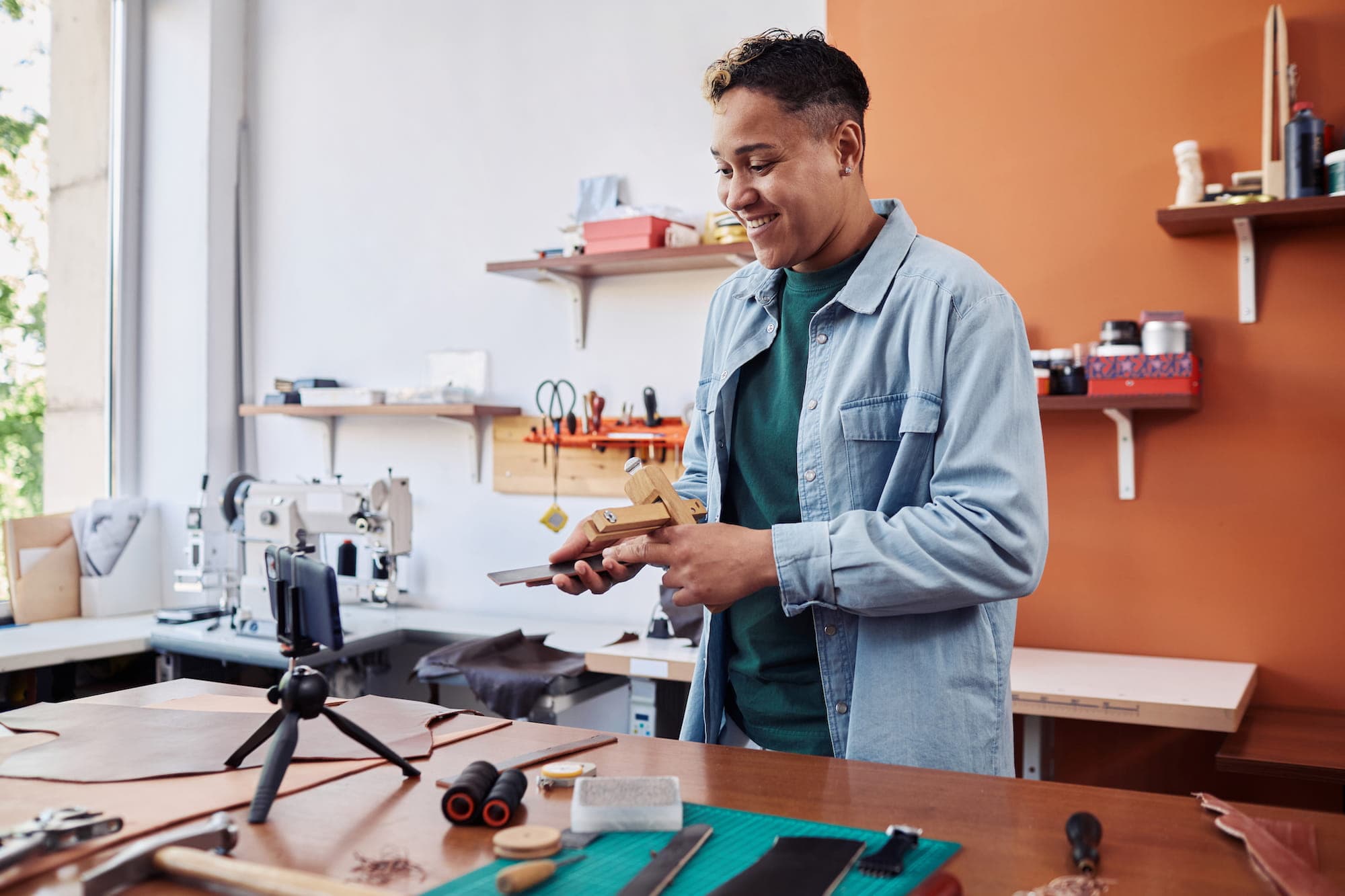 man in a shirt smiling while watching a DYI video in his workshop