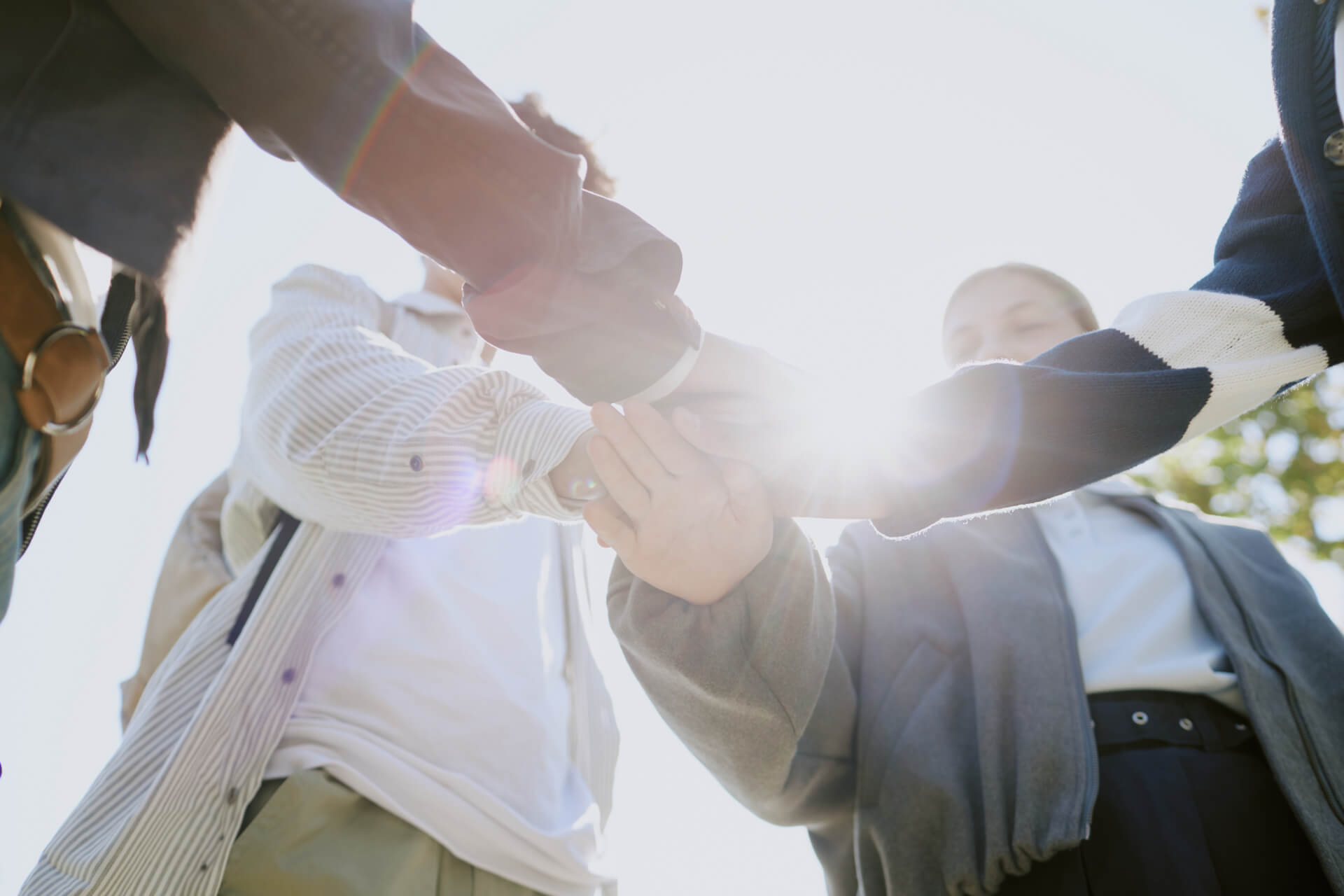 A diverse group of team members putting their hands together to symbolize unity and collaboration