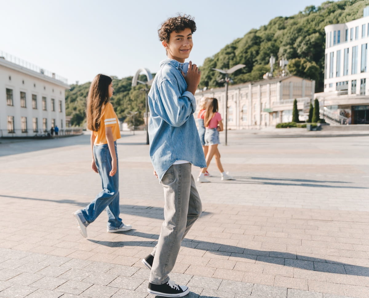 Portrait of a stylish teenage boy wearing wireless headphones